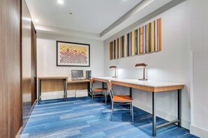 A modern office space with a desk, computer, and chair, a colorful abstract painting, and a striped wall art piece. - Holiday Inn Express & Suites, Lake Elsinore by IHG (Lake Elsinore)