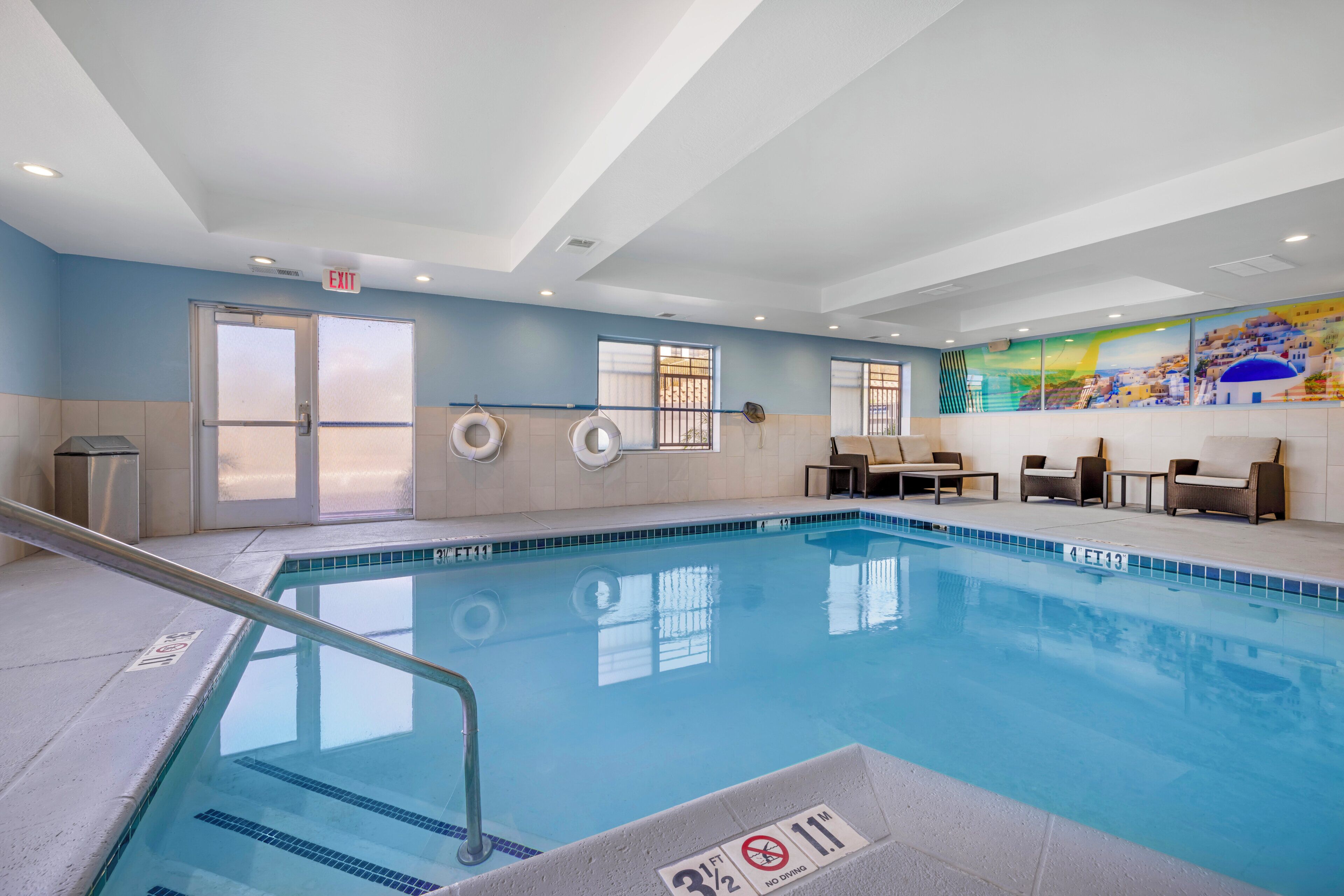 A swimming pool with a lifebuoy, a chair, and a table.