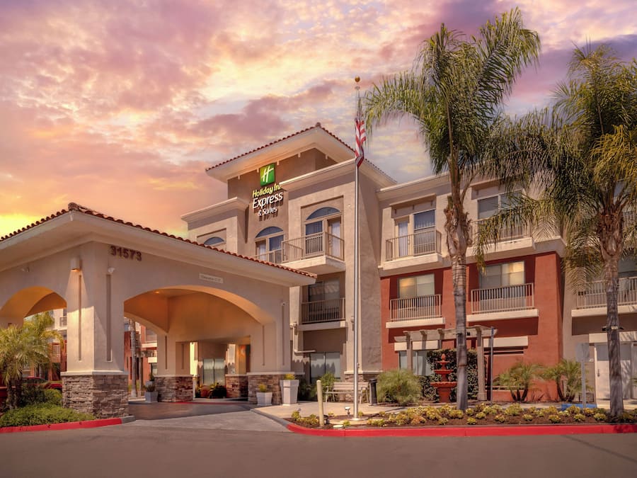 Un hotel Holiday Inn Express & Suites con cielo despejado y palmeras.