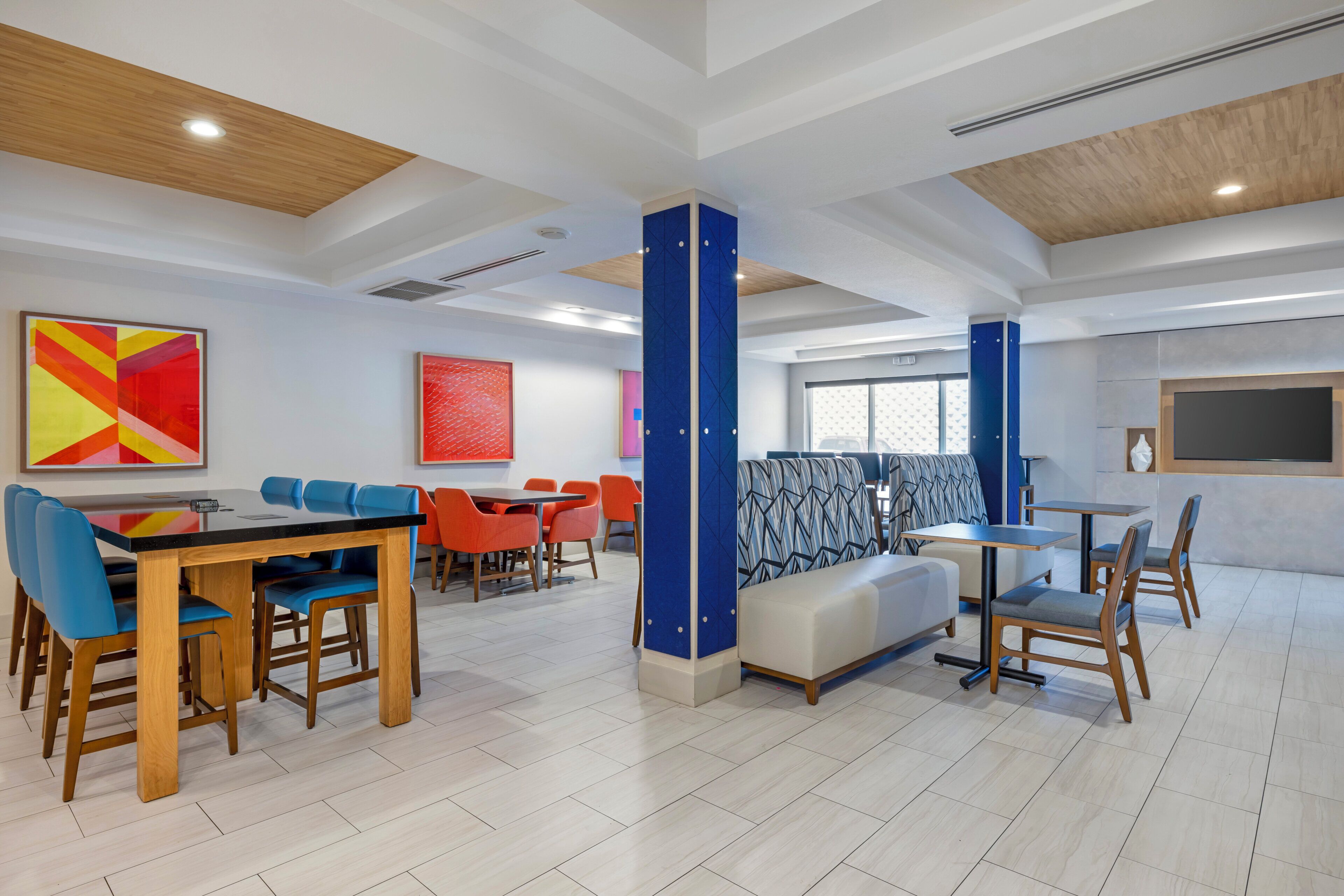 A modern interior with a dining area, seating arrangements, and artwork on the walls.