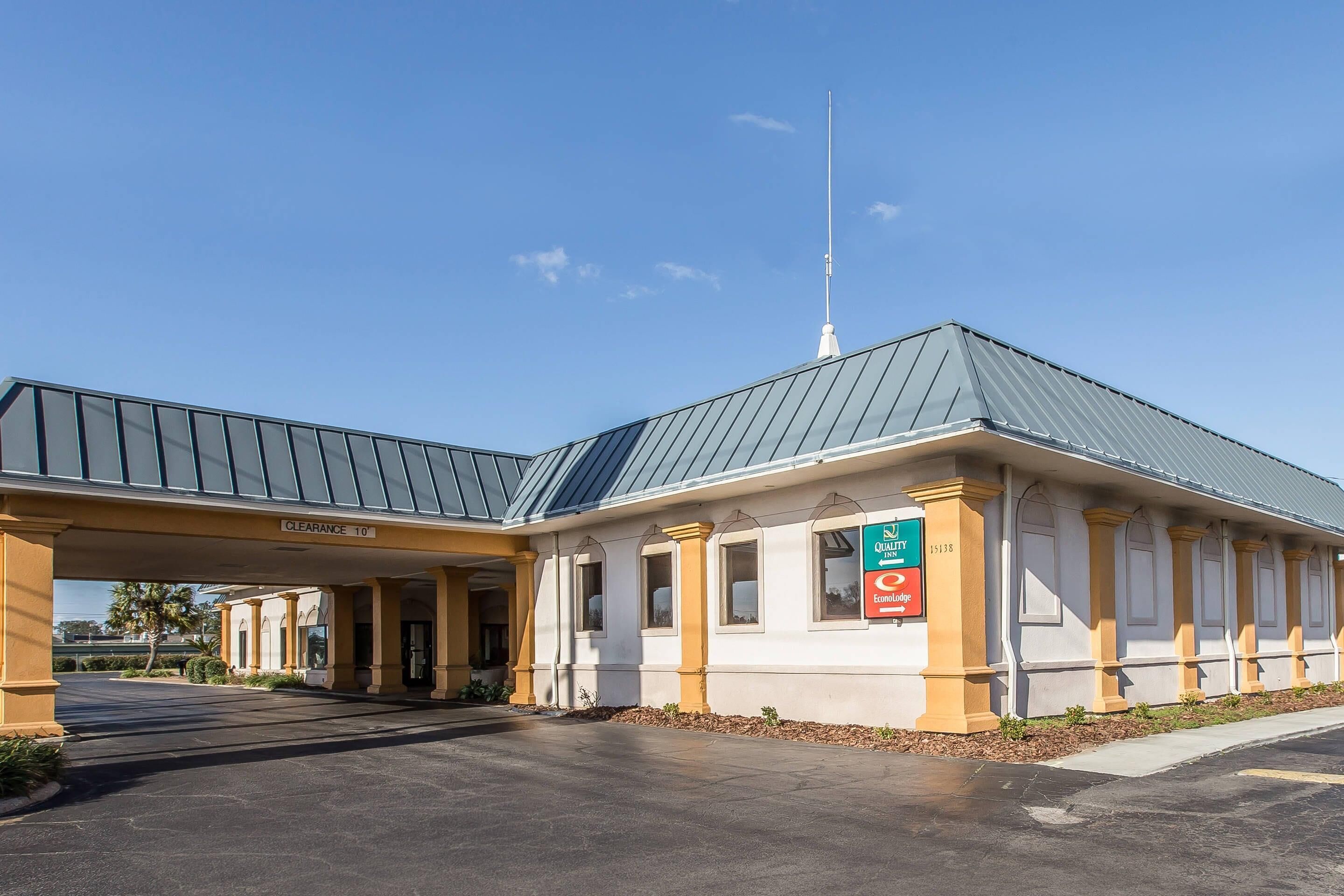 A building with a covered entrance, a clear sky, and a sign indicating a clearance of 10 feet.