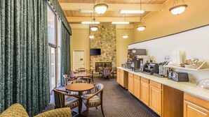 A hotel room with a dining area, a kitchen, and a stone wall. - Econo Lodge Thomasville (Thomasville)