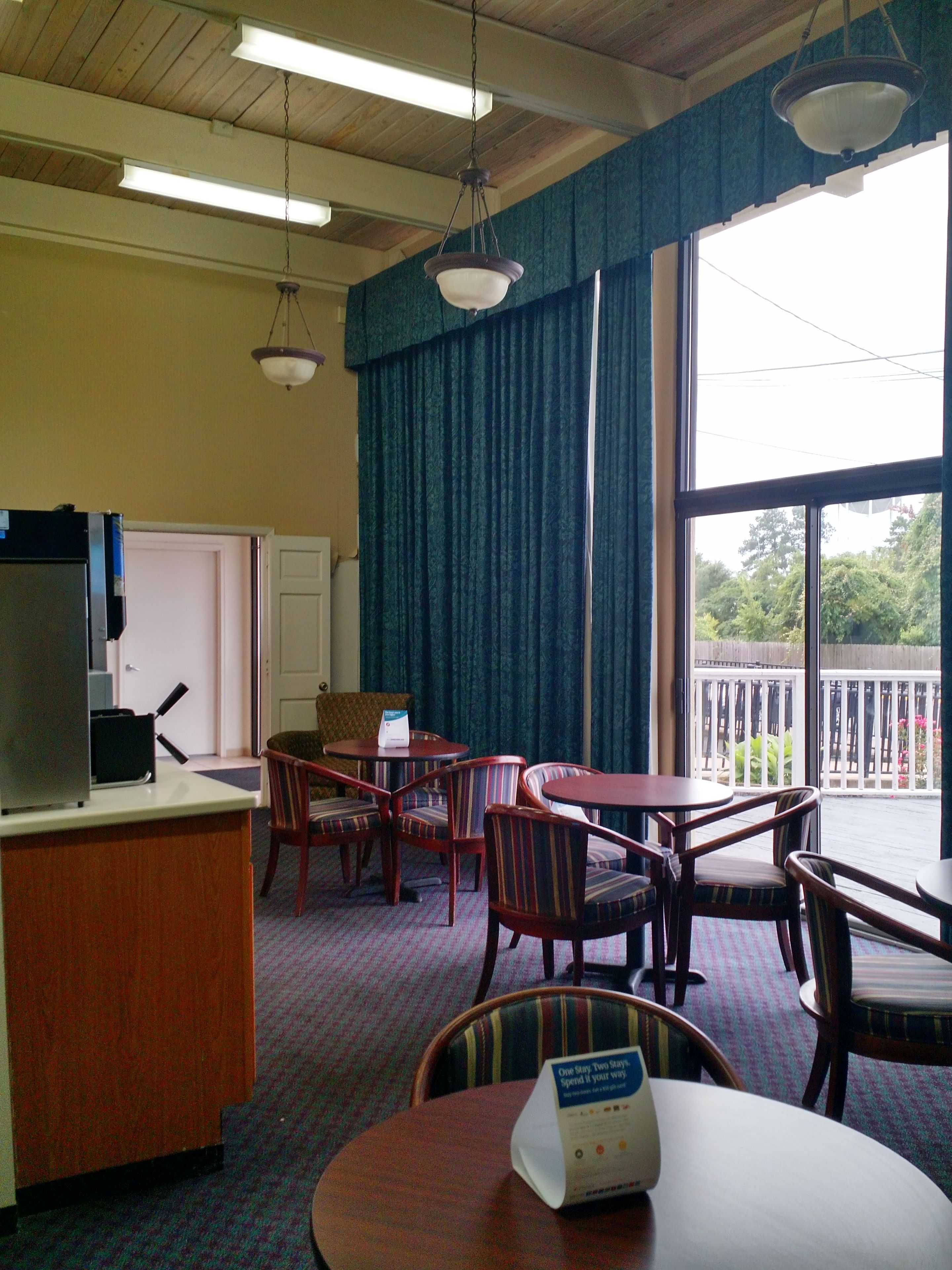 Une chambre d’hôtel dotée d’un coin repas, d’un bureau et offrant une vue sur l’extérieur.