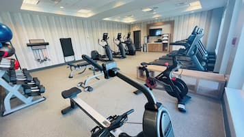 Ein Fitnessstudio mit Cardiogeräten, Kraftmaschinen und Kurzhanteln.