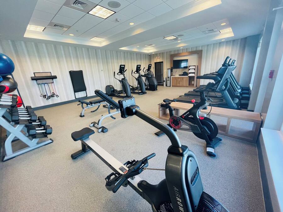 Ein Fitnessstudio mit Cardiogeräten, Kraftmaschinen und Kurzhanteln.
