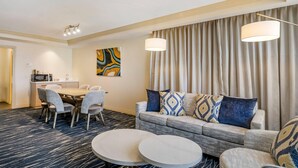 Habitación de hotel con comedor, sofá y una pequeña mesa.