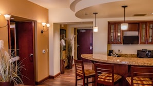 A kitchen with a curved island, wooden cabinets, and a built-in microwave.