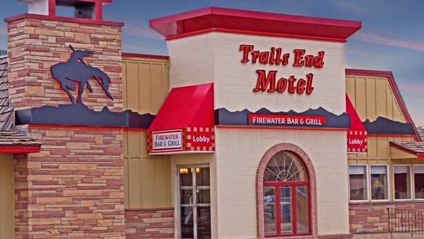 Le Trails End Motel se distingue par sa façade en pierre, une silhouette de cheval en relief et son bar-restaurant, le Firewater Bar & Grill.
