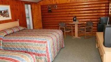 A room with two beds, a small table, and a chair.