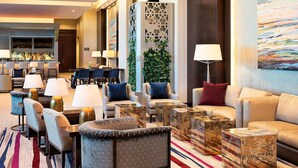 A hotel lobby with seating arrangements, a bar area, and a large abstract painting on the wall. - The Westin Edina Galleria (Edina)