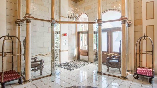 A grand lobby with a tiled floor, ornate columns, and a chandelier. - St Christophe Hotel & Spa, an Ascend Collection Hotel (Granby)