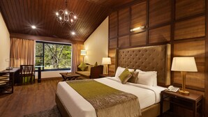 Une chambre avec un grand lit, un bureau et une chaise. Il y a une fenêtre avec des rideaux, un lustre et une table de chevet avec une lampe.