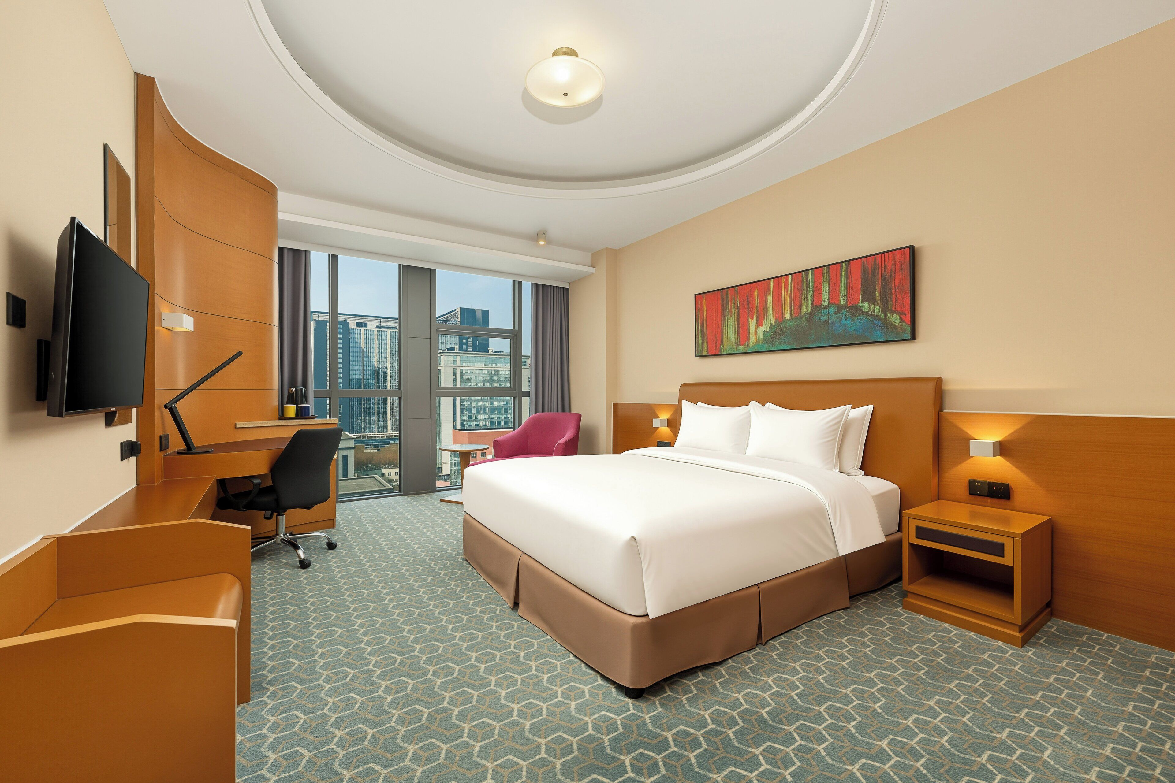 A hotel room with a large bed, a desk, a chair, a TV, a nightstand, and a painting.