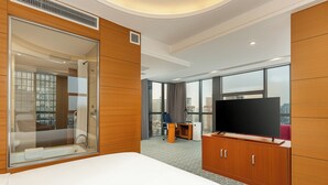 A hotel room with a large bed, a TV, a desk, and a view of the city. - Holiday Inn Express Beijing Wangjing Center by IHG  (Beijing)