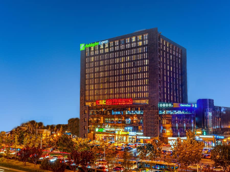 Un hotel de gran altura con varios pisos, ventanas amplias y un llamativo letrero de Holiday Inn Express.