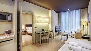 Hotelkamer met een bed, bureau, stoel, televisie en een magnetron.