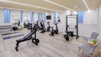 Academia moderna com diversos equipamentos de exercício, incluindo esteiras, bicicletas ergométricas e aparelhos de musculação.