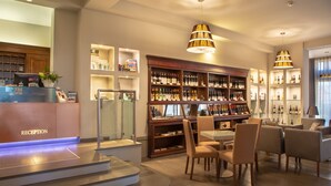 A reception area with a reception desk, seating area, and a wine display.