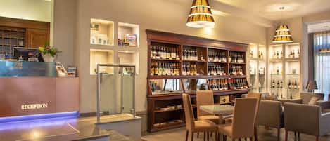 A reception area with a reception desk, seating area, and a wine display.