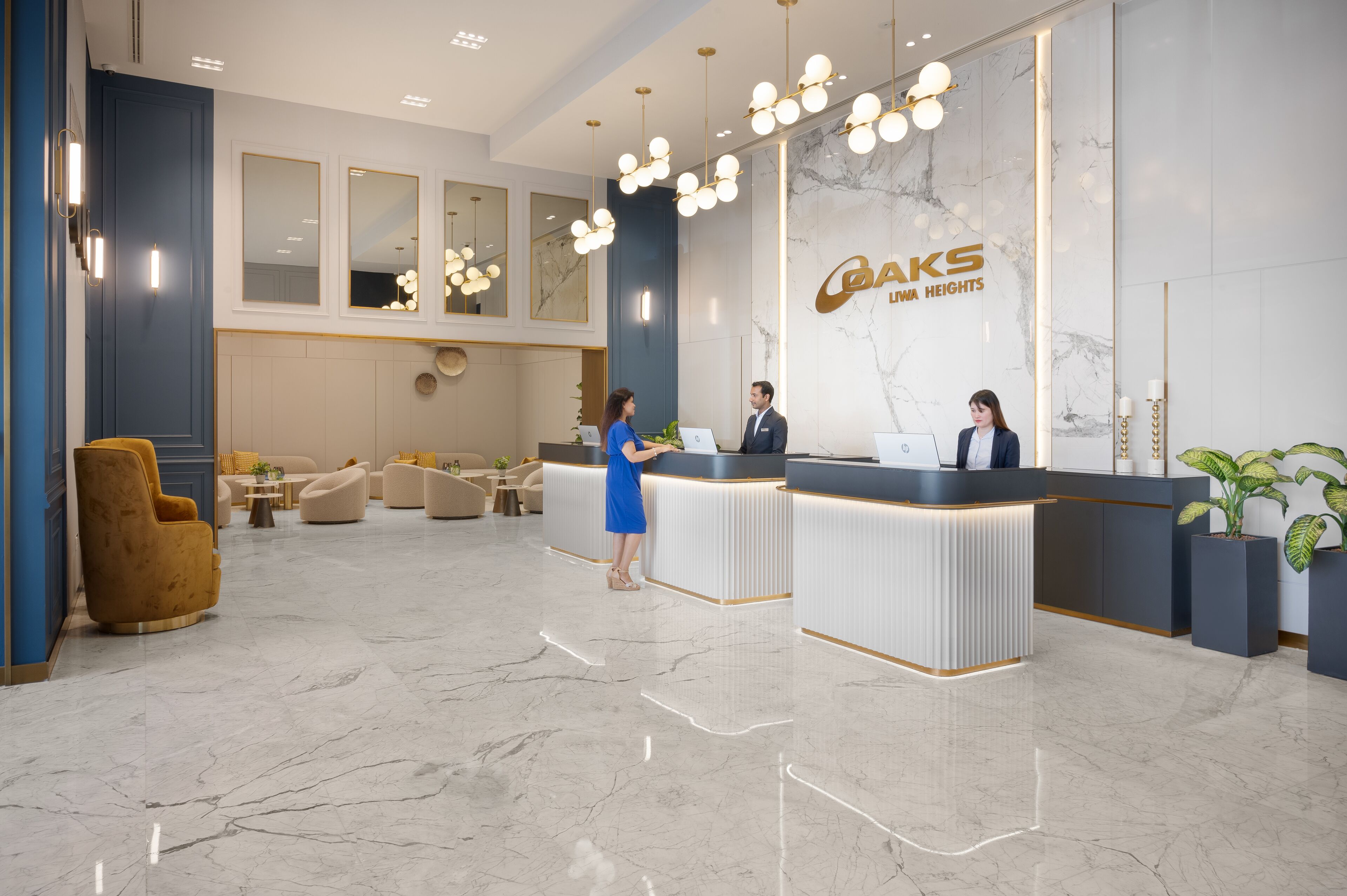 A modern hotel reception area with a marble floor, a reception desk, and a large mirror.