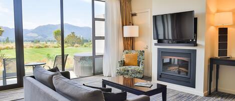 A modern living room with a sofa, coffee table, and fireplace.