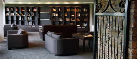 A modern living room with sofas, a coffee table, and a bookshelf filled with books.