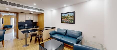Un salon moderne comprenant un canapé, une table basse et un coin cuisine avec une table à manger.