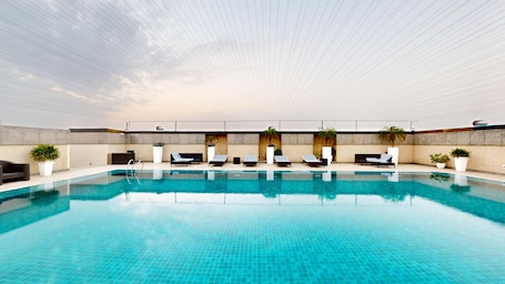 An indoor swimming pool with lounge chairs and potted plants.. Svelte Delhi, a member of Radisson Individuals