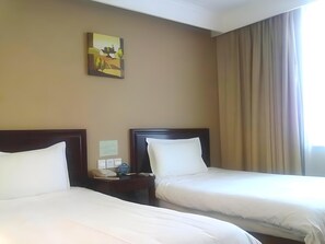 A hotel room with two beds, a painting on the wall, a nightstand with a phone, and a window with curtains. - Greentree Inn Beijing Fangzhuang Hotel (Beijing)