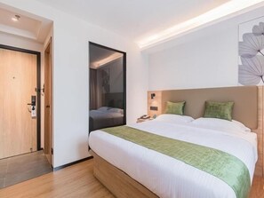 A modern hotel room with a large bed, a bedside table, a nightstand, and a door. - Greentree Inn Beijing Fangzhuang Hotel (Beijing)