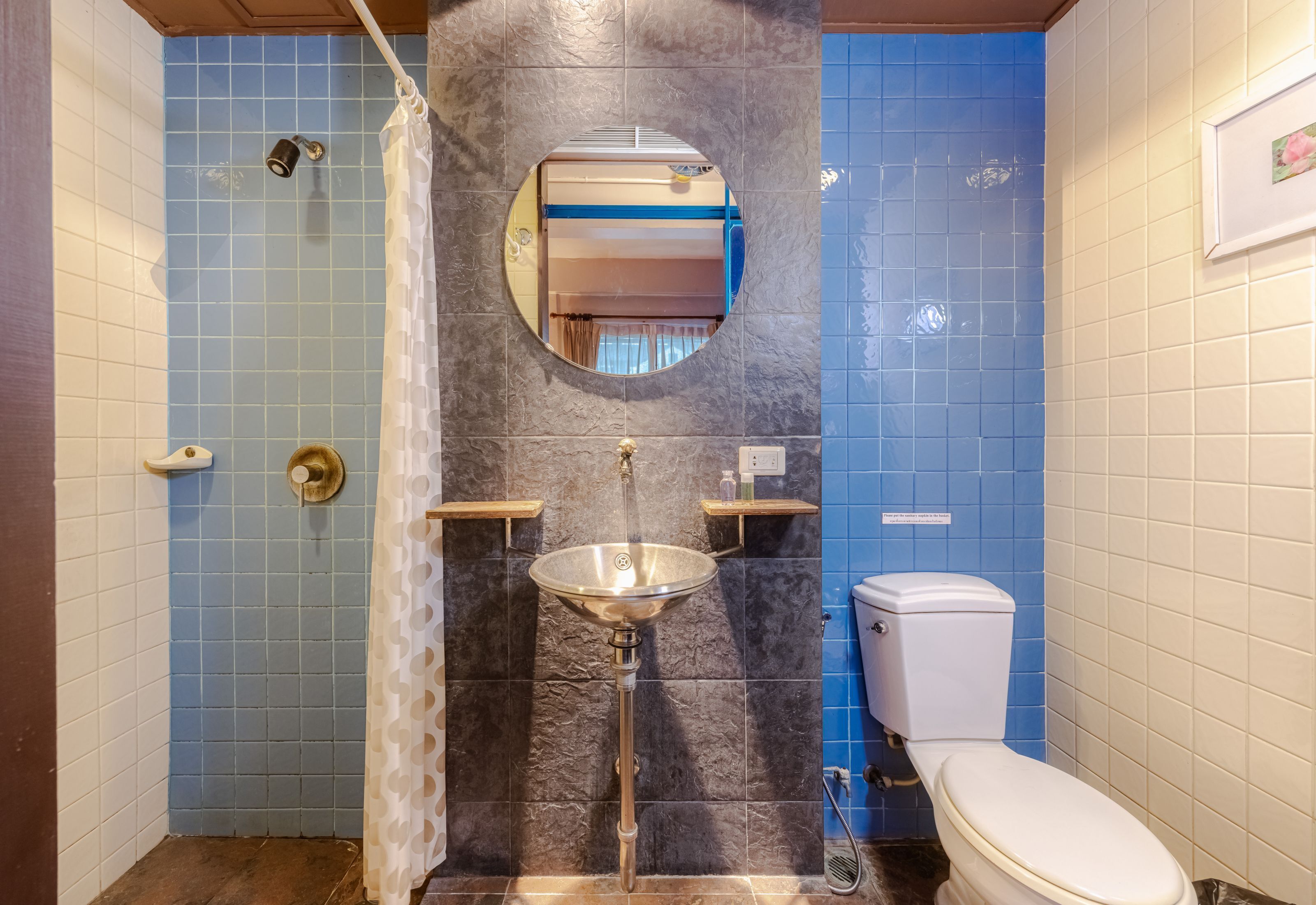 Un baño con ducha, lavabo, inodoro y espejo.