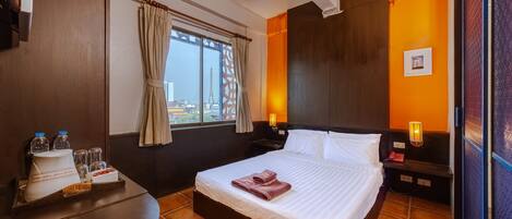 A hotel room with a bed, a nightstand, a window with curtains, a view of the Eiffel Tower, and a tray with breakfast items.