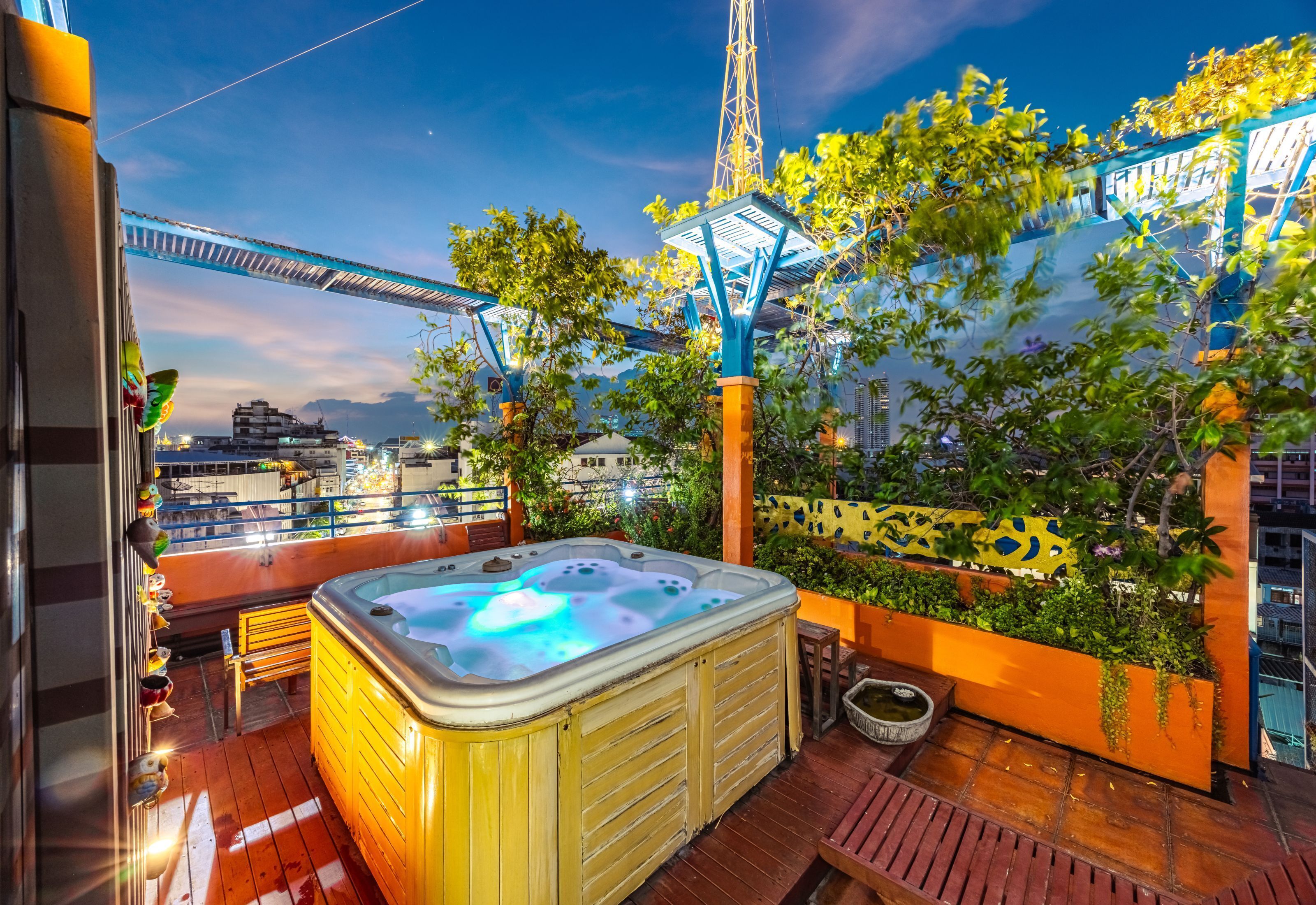 A rooftop terrace with a hot tub, wooden deck, and a view of a bridge and cityscape.
