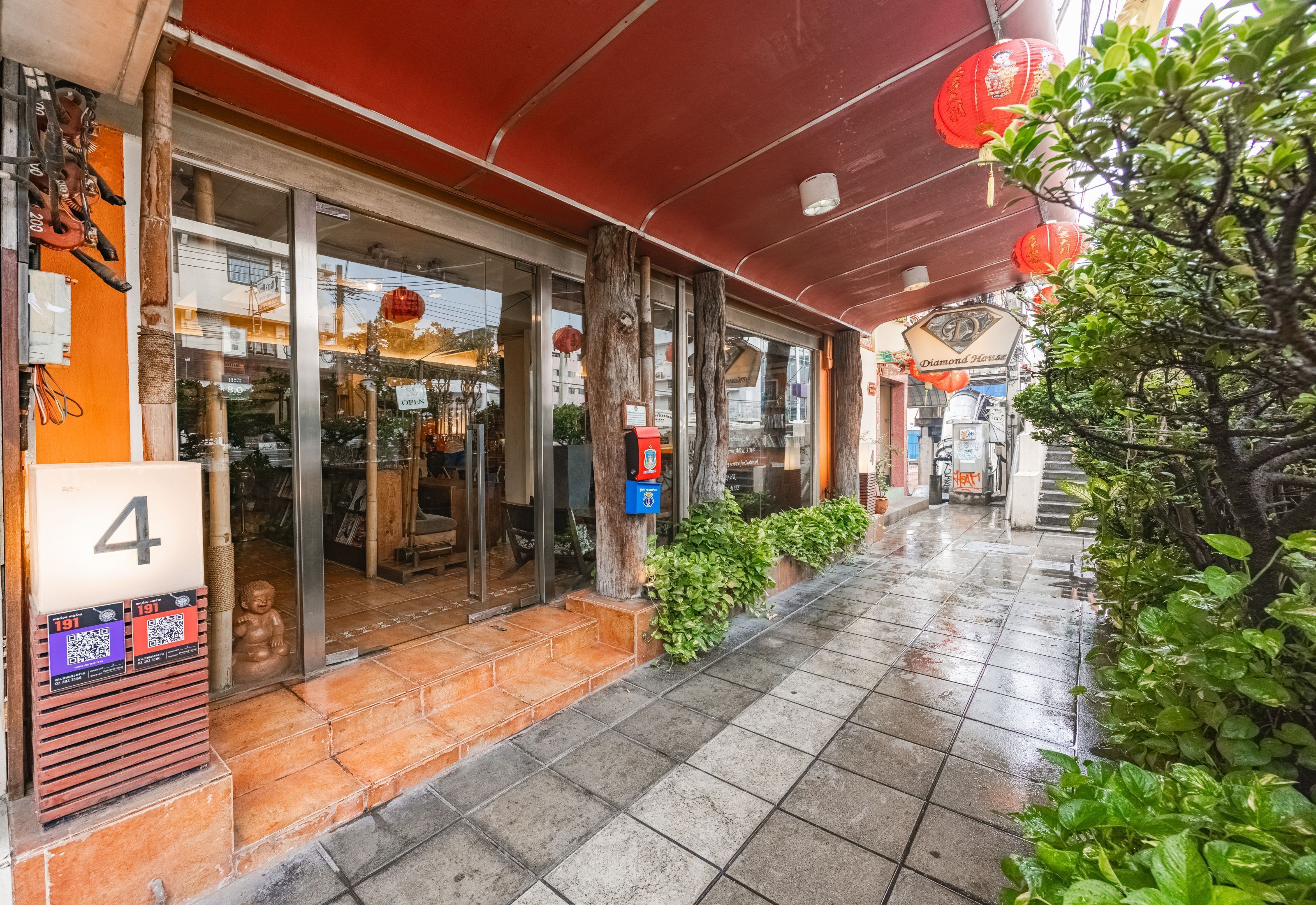 A storefront with a red awning, a number '4' sign, and a QR code.