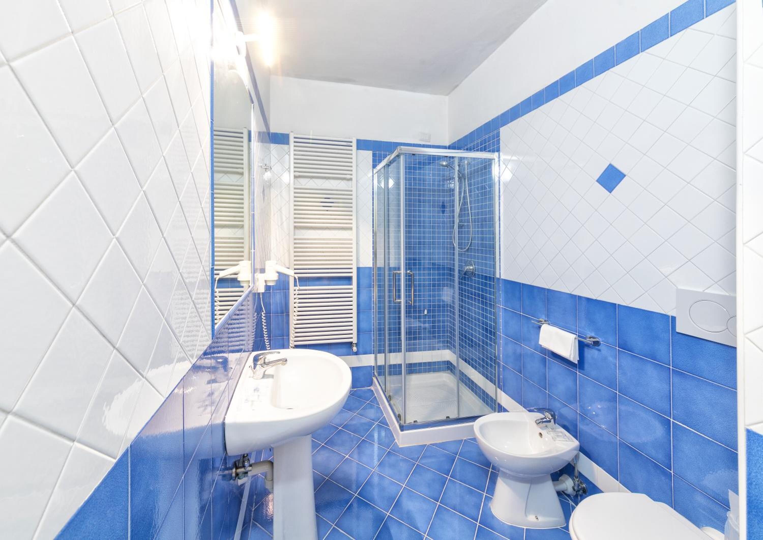 A bathroom with a shower, toilet, and sink.