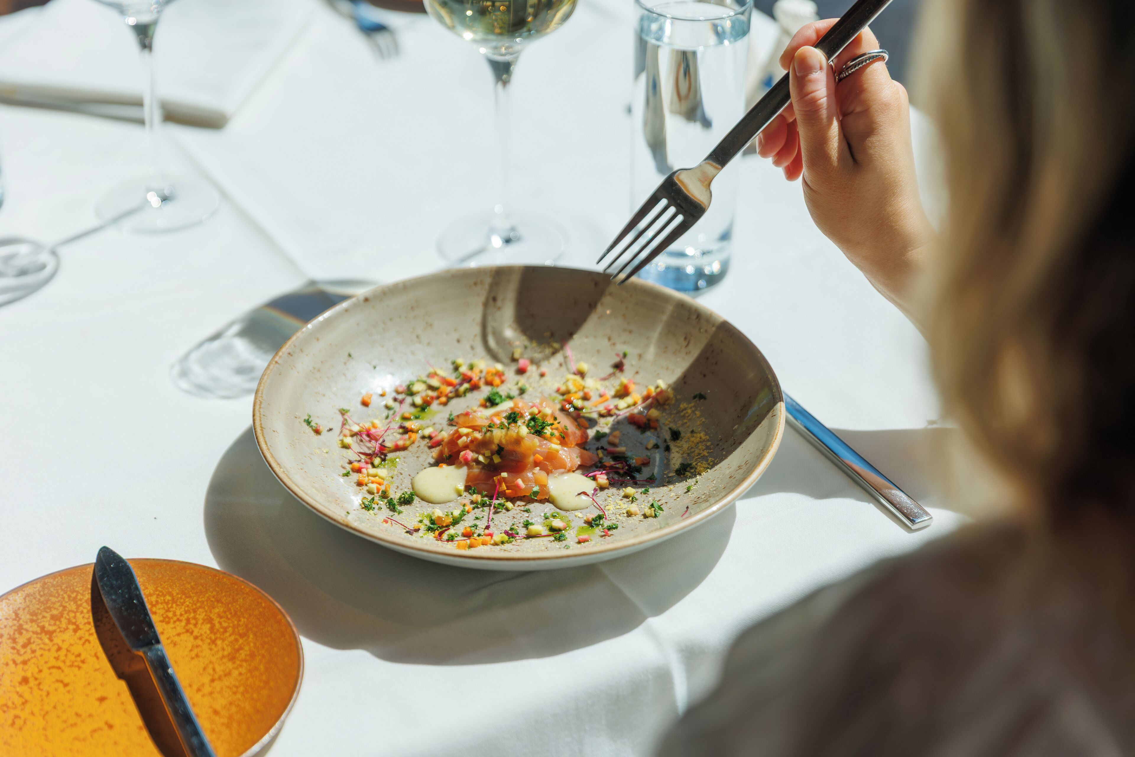 A dining table with a plate of food, a fork, and a knife.