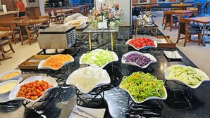 Uma área de buffet com diversas opções de comida e um espaço para café.