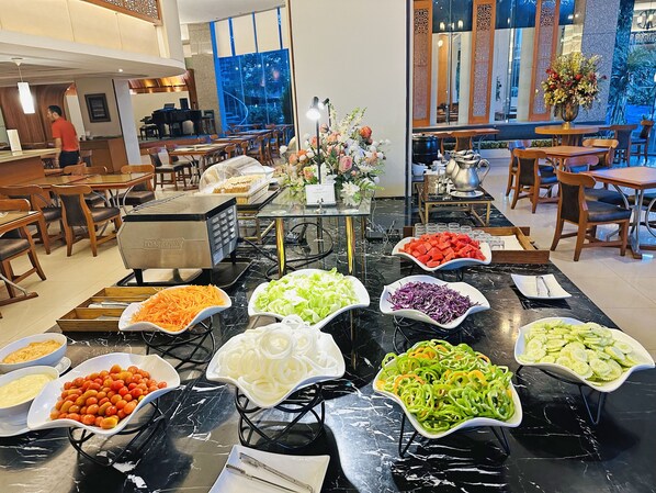 A buffet area with various food options and a coffee station.