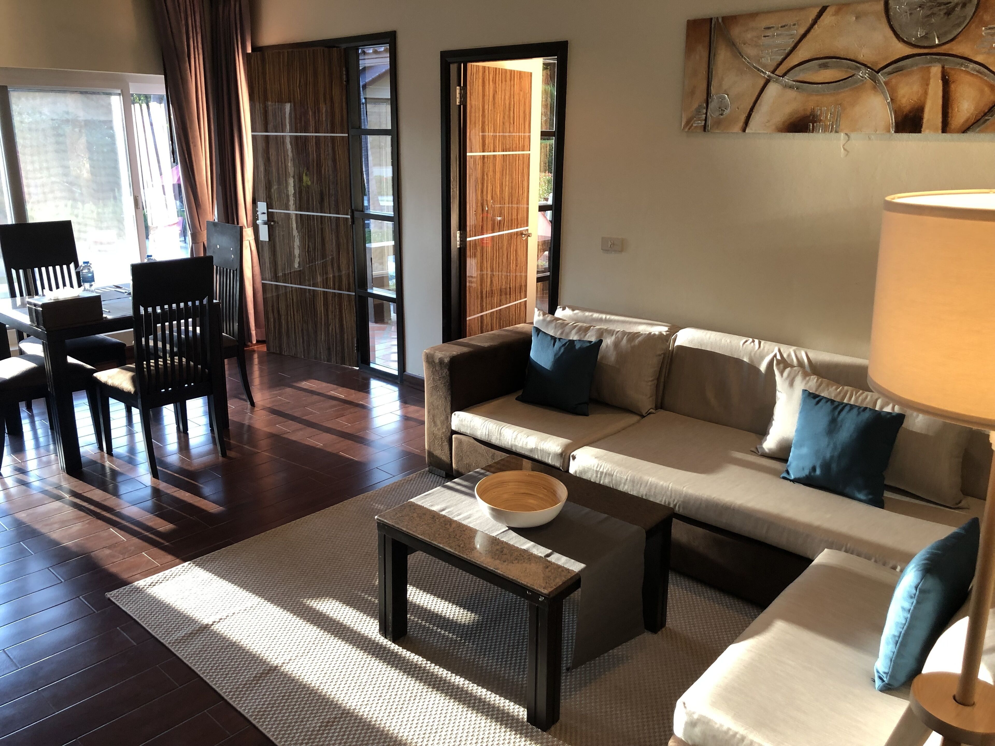 A modern living room with a sofa, coffee table, and dining area.