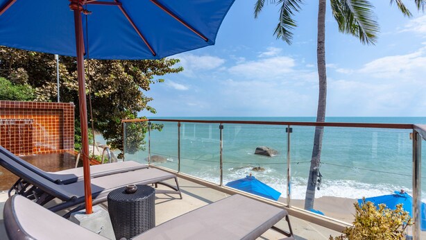 A balcony with lounge chairs, a blue umbrella, and a view of the ocean. - Royal Beach Boutique Resort & Spa (Koh Samui)