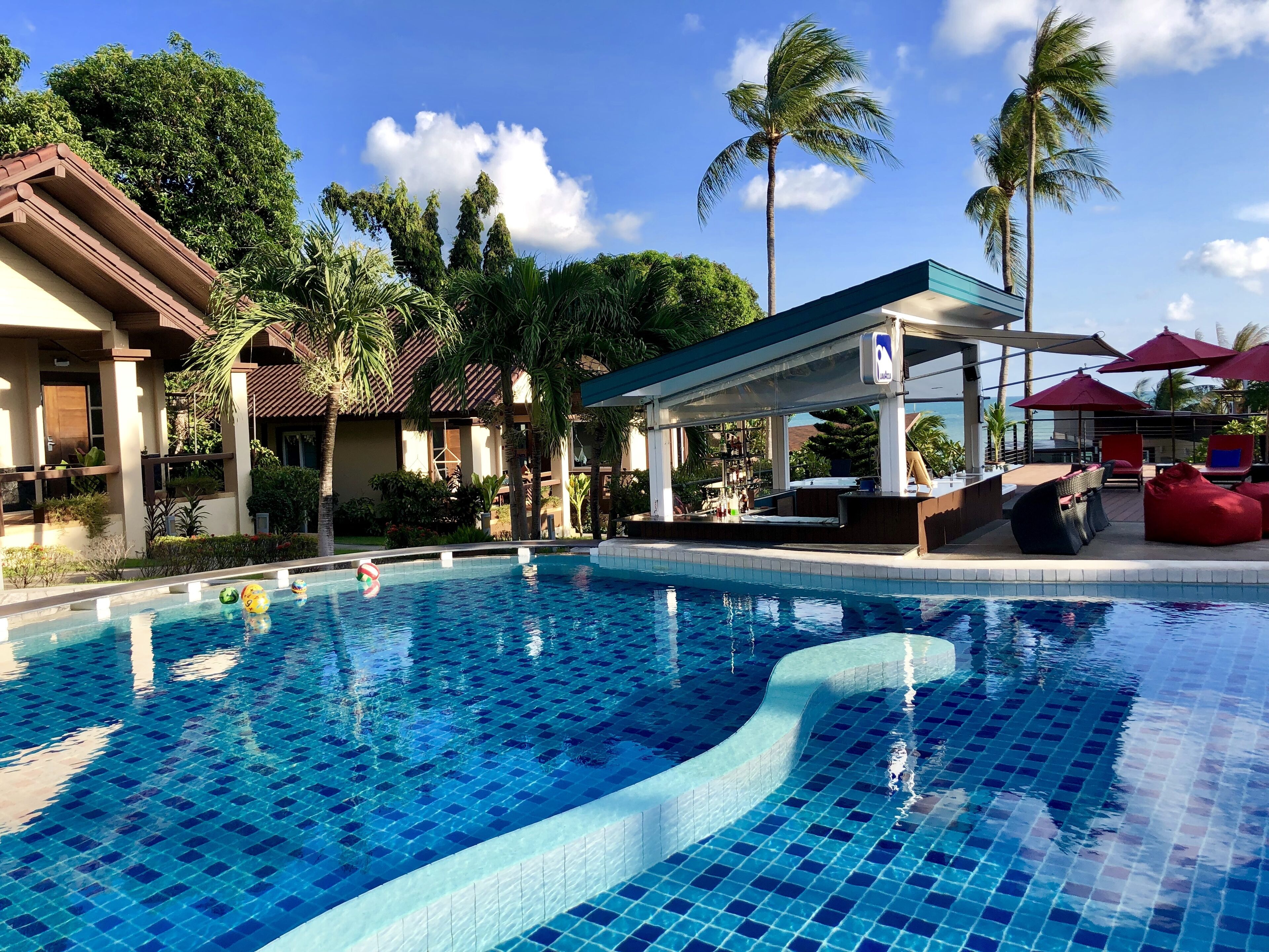 Una piscina al aire libre, sillones reclinables de piscina