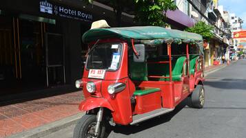 Een rode en groene tuk-tuk geparkeerd op een stadsstraat.