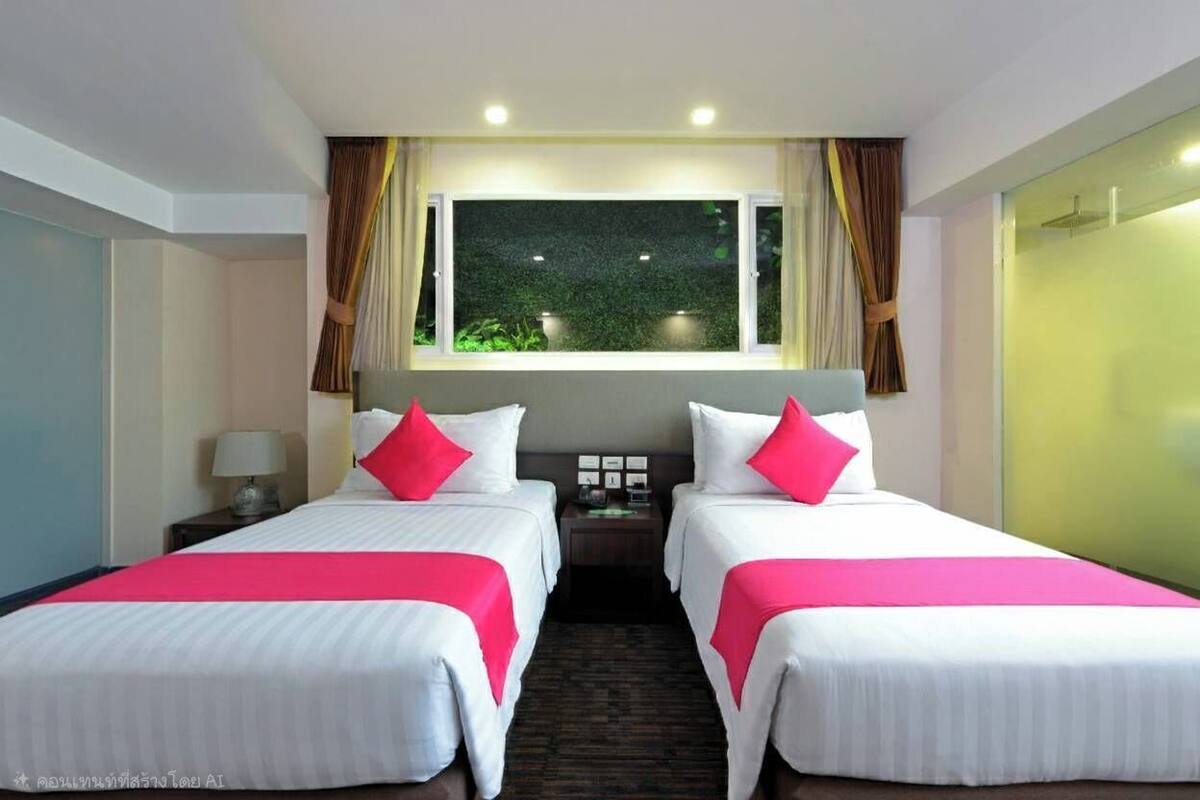 Une chambre d’hôtel avec deux lits, une fenêtre avec des rideaux, une table de chevet avec une lampe et une vue sur la verdure.
