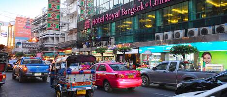 A busy street with a building labeled "Hotel Royal Bangkok o Chinatown."