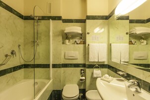 Un bagno con doccia vetrata, vasca, WC e lavandino.