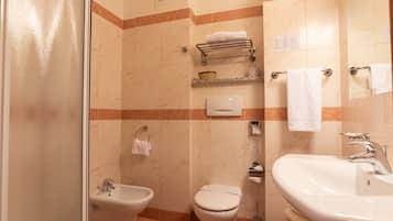 Un bagno con bidet, water e lavabo.