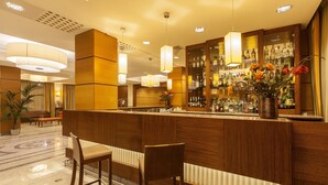 A bar area with wooden paneling, bar stools, and a variety of liquor bottles. - NilHotel Florence (Florence)