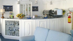 Una zona de bar con una máquina de café, un estante con botellas y una exhibición de barcos modelo.