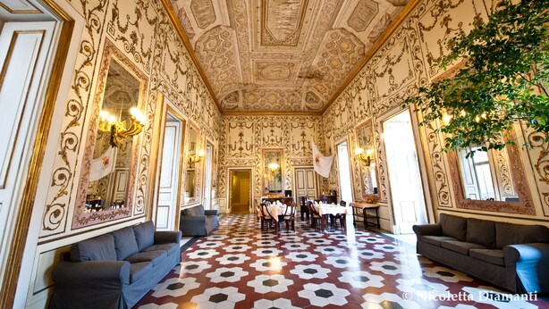 An opulent room with ornate ceiling and walls, a patterned floor, and a dining area with tables and chairs. - Decumani Hotel De Charme (Naples)