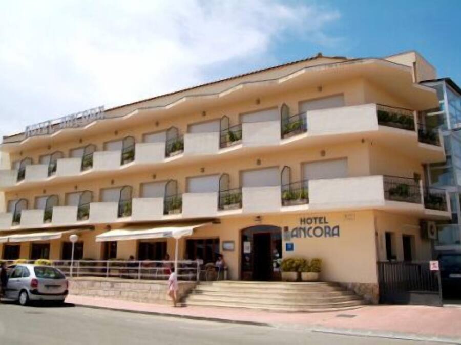 A multi-story hotel with balconies and a sign reading "HOTEL ANCORA".